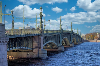 Bridge over river against cloudy sky