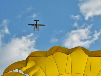 Low angle view of yellow flag against sky