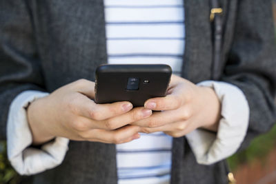 Midsection of man using mobile phone