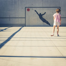 Full length rear view of girl standing in basketball court