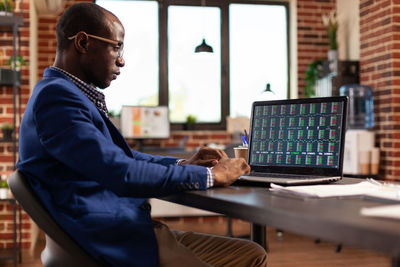 Midsection of man using laptop at office