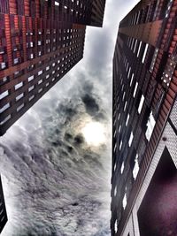 Low angle view of buildings against cloudy sky