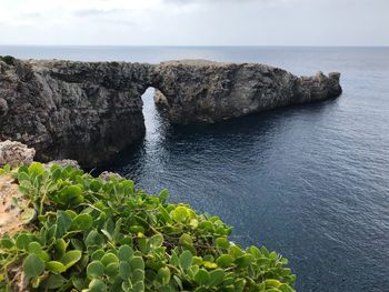 Rock formation in sea against sky