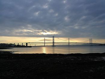 Bridge over sea against sky during sunset