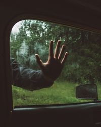 Close-up of hand holding glass window