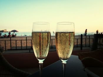 Close-up of champagne on table at beach