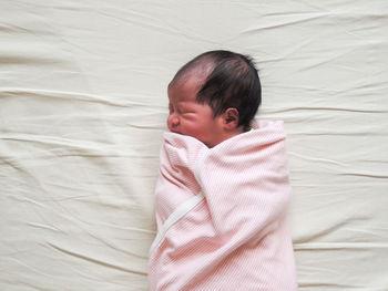 High angle view of baby sleeping in bed