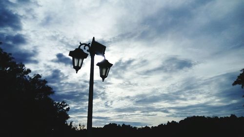 Low angle view of silhouette trees against sky