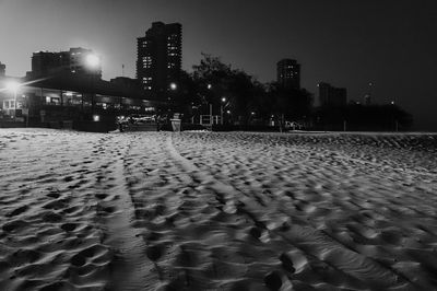 Sandy beach against buildings in city