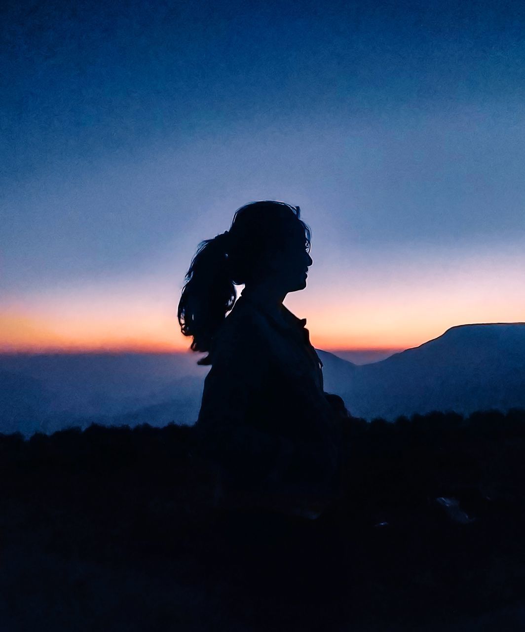 SILHOUETTE WOMAN STANDING AGAINST ORANGE SKY