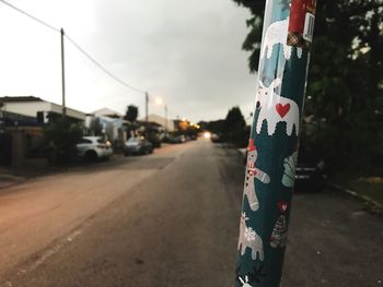 Close-up of road by street against sky