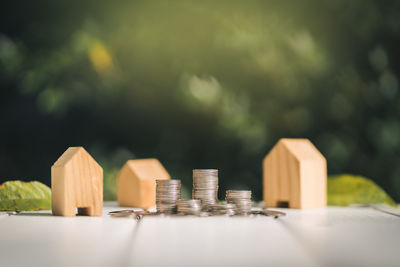 Close-up view of coins with house models on table