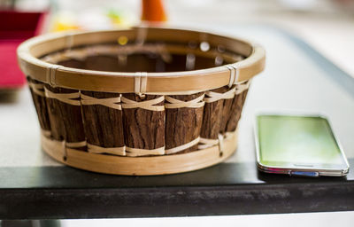 Close-up of basket and mobile phone on table