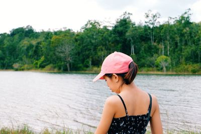 Woman standing by lake against sky