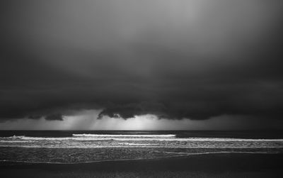 Scenic view of sea against storm clouds
