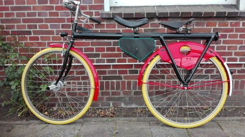 Bicycle parked against brick wall