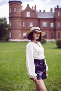 Young woman wearing hat standing on field