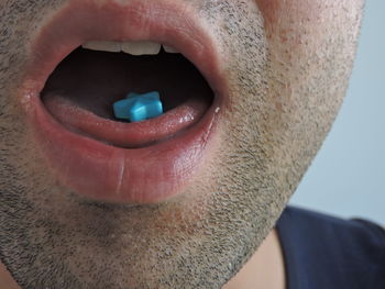 Close-up of man eating blue candies