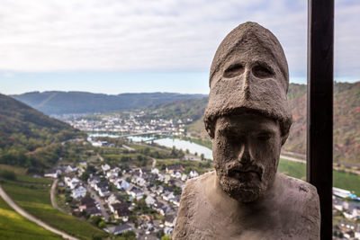 Close-up of statue against buildings in city