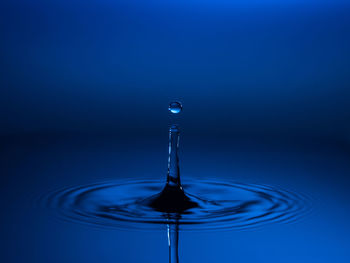 Close-up of water drop against blue background