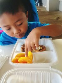 Cute boy having food at home