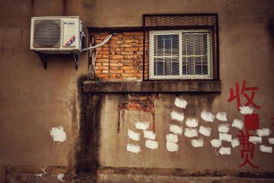 Air conditioner mounted on damaged wall