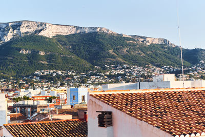 Town by mountain against clear sky