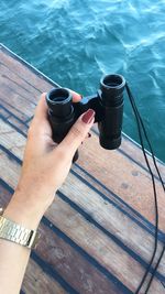 High angle view of hand holding drink at water