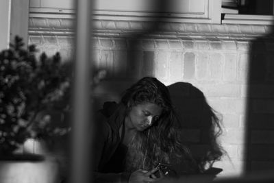 Woman using phone while sitting at home