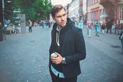 Young man standing on street in city