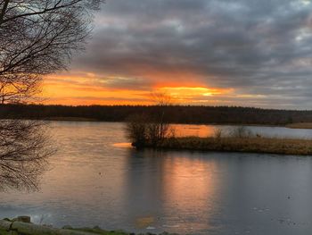 Scenic view of lake against orange sky