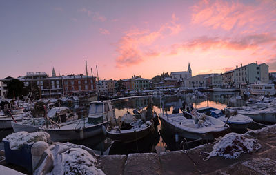 Boats moored at harbor during sunset