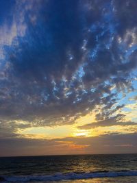 Scenic view of sea against cloudy sky at sunset