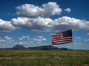 Flag on landscape against sky