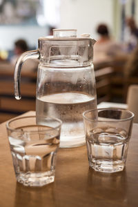 Close-up of water in glasses and jar on restaurant table