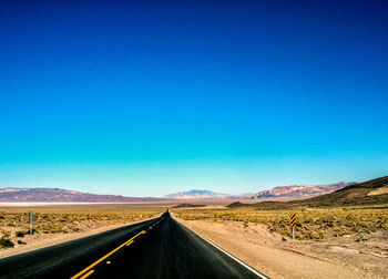 Empty road along countryside landscape