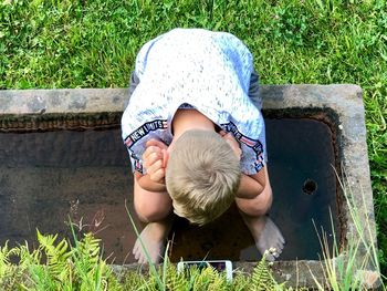 High angle view of boy sitting on grass