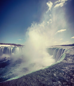 Scenic view of waterfall against sky