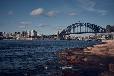 Arch bridge over sea against buildings in city