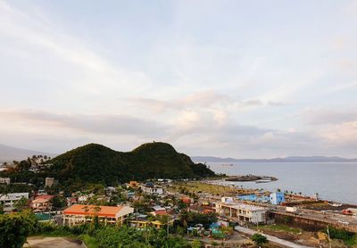 High angle view of townscape by sea against sky