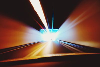 Illuminated road seen through car windshield at night