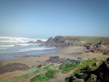 Scenic view of beach against clear blue sky