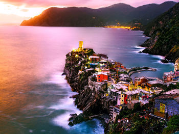 High angle view of sea and buildings against sky during sunset