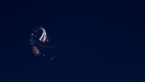 Low angle view of illuminated light against sky at night