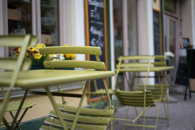 Empty chairs and tables at sidewalk cafe