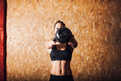 Full length of woman standing against wall