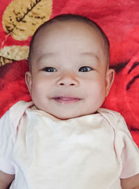 Portrait of cute baby lying on bed