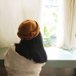 Rear view of woman looking through window at home