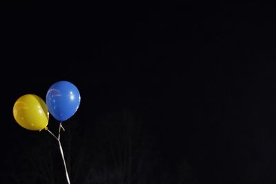 Low angle view of balloons against sky at night