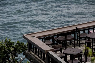 High angle view of empty bench by sea